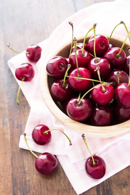 Fresh red cherries in bowl on a wooden table