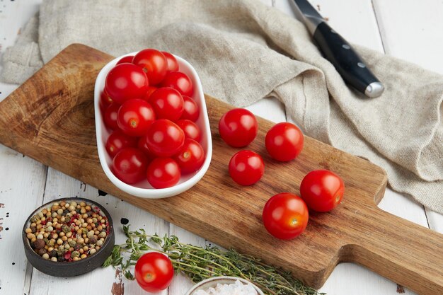 Fresh red cherry tomatoes on white wooden background