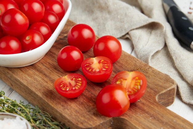 Fresh red cherry tomatoes on white wooden background