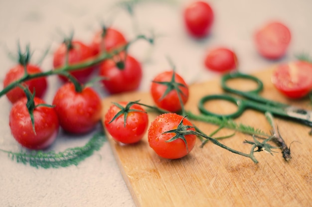Fresh red cherry tomatoes with herbs on vintage background at table close up. Top view. Flat lay