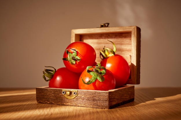 Fresh red cherry tomatoes in a wooden gift box in day light.