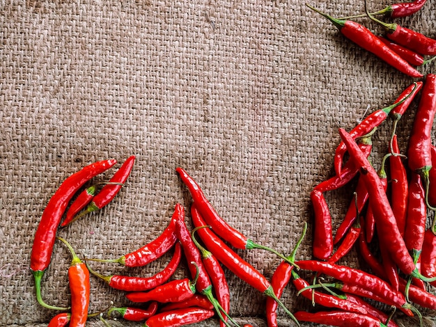 Fresh red chili peppers on vintage cloth background.