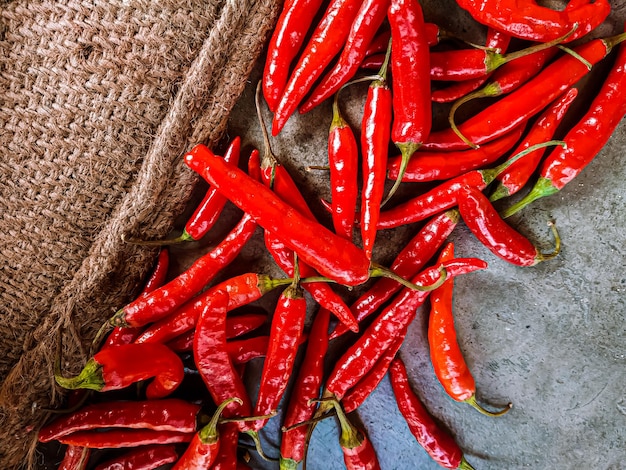 Fresh red chili peppers on vintage cloth background.