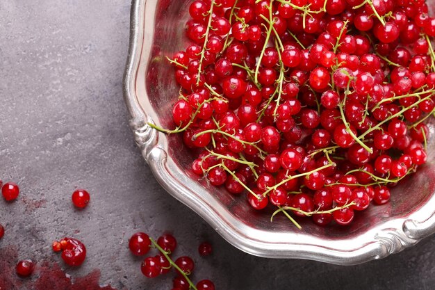 Fresh red currants in bowl on table close up