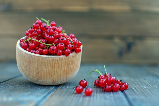 Fresh red currants in a wooden bowl. Useful berries and mint. 