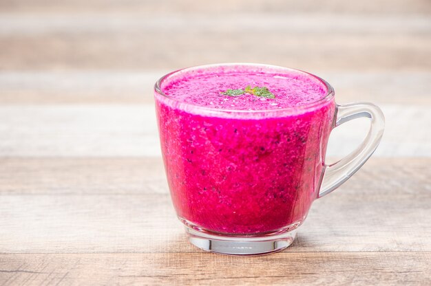 Fresh red dragon (pitaya) fruit juice in glass mug.