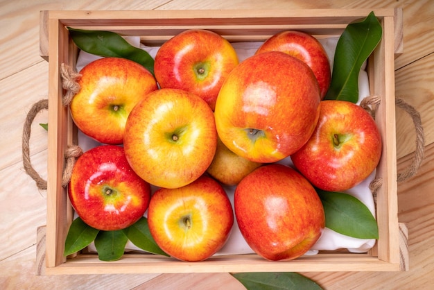 Fresh red Envy apple in wooden basket on wooden background Envy apple on wooden box packaging