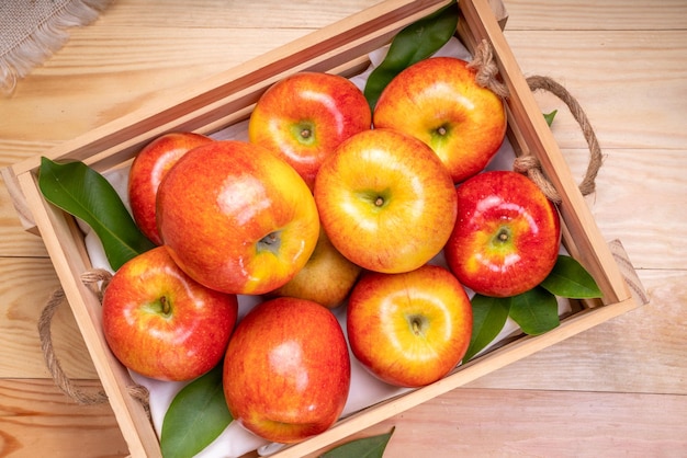 Fresh red Envy apple in wooden basket on wooden background Envy apple on wooden box packaging