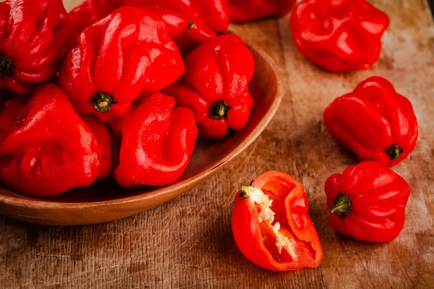 Fresh red hot habanero chili peppers on wooden background