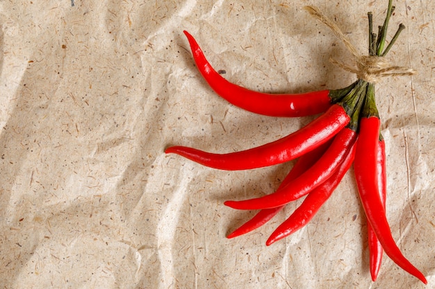 Fresh red hot peppers on craft paper