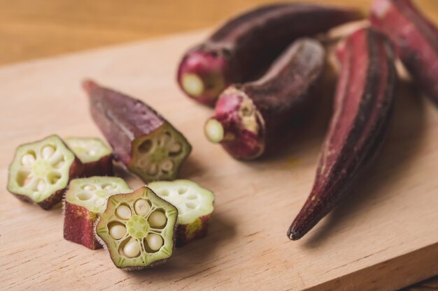 Fresh Red okra on wooden background.