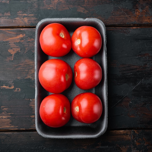 Fresh red organic tomatoes, on dark wooden table