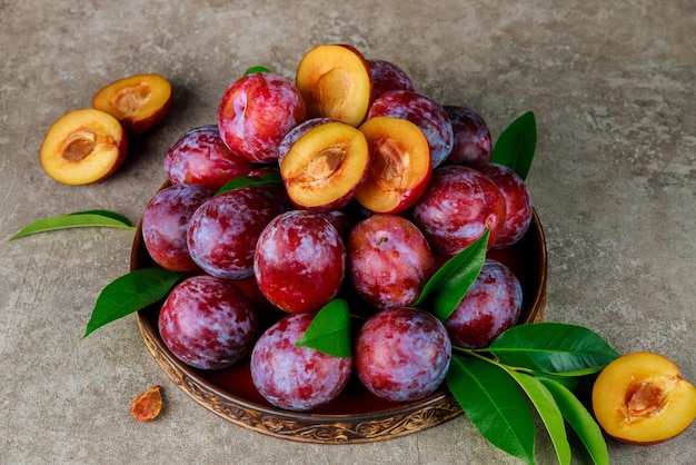 Fresh red plum on big plate. Close up.