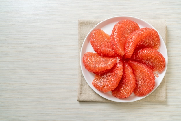 fresh red pomelo fruit or grapefruit on plate