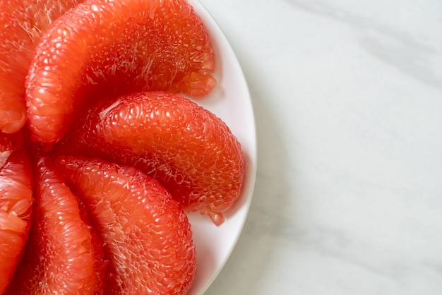 fresh red pomelo fruit or grapefruit on plate