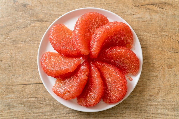 fresh red pomelo fruit or grapefruit on plate