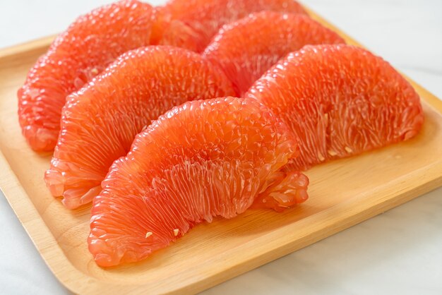 fresh red pomelo fruit or grapefruit on plate