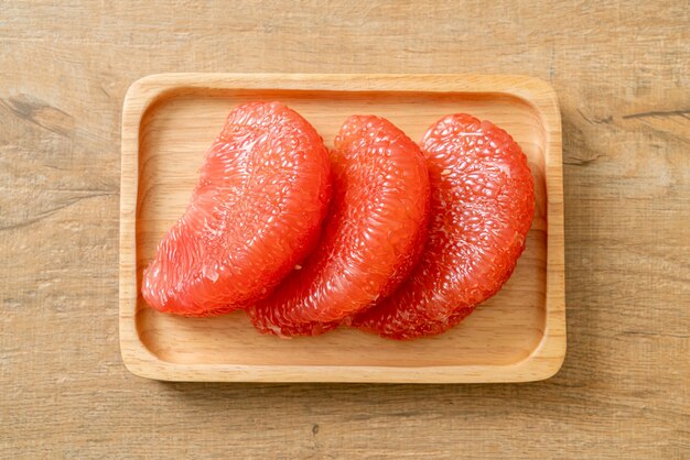 fresh red pomelo fruit or grapefruit on plate