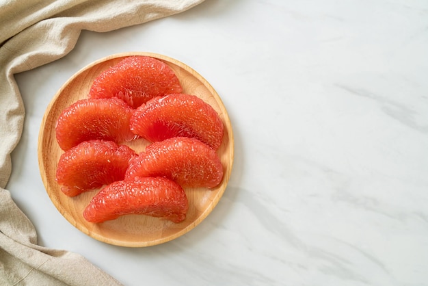 fresh red pomelo fruit or grapefruit on plate