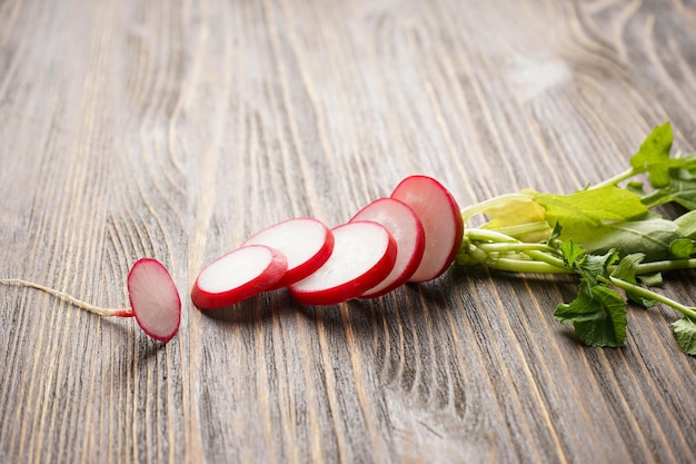 Fresh red radish slices on wooden background