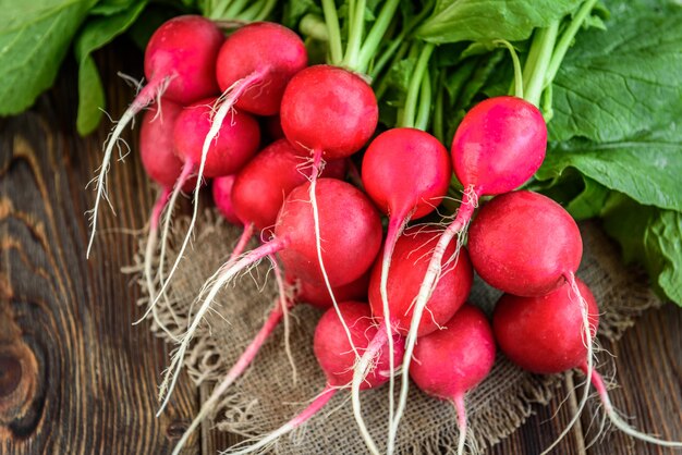 Fresh red radish on wooden background.