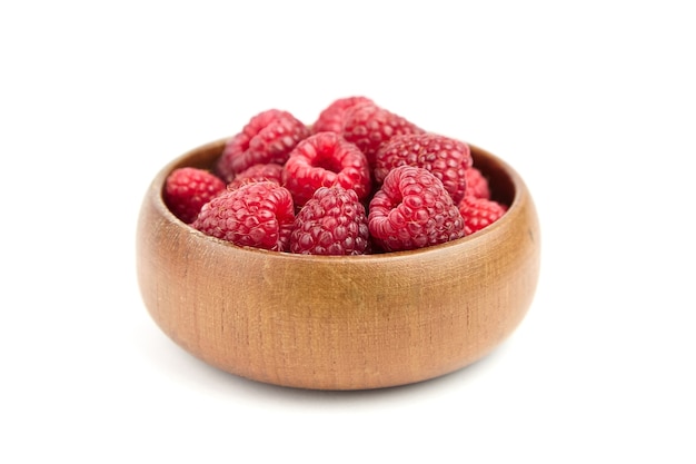 Fresh red raspberries in wooden bowl isolated