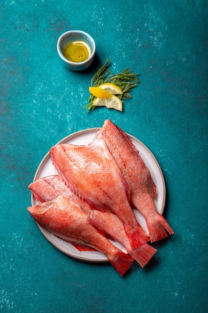 Fresh red sea bass on blue background top view copy space