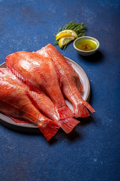 Photo fresh red sea bass on blue background top view copy space