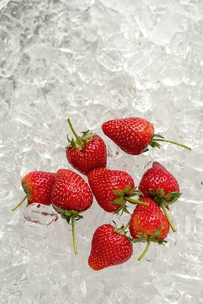 Fresh red strawberries on ice tube background