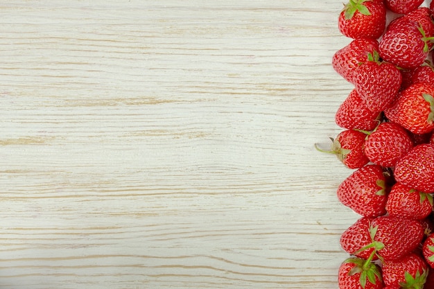 Photo fresh red strawberries on a white wooden background