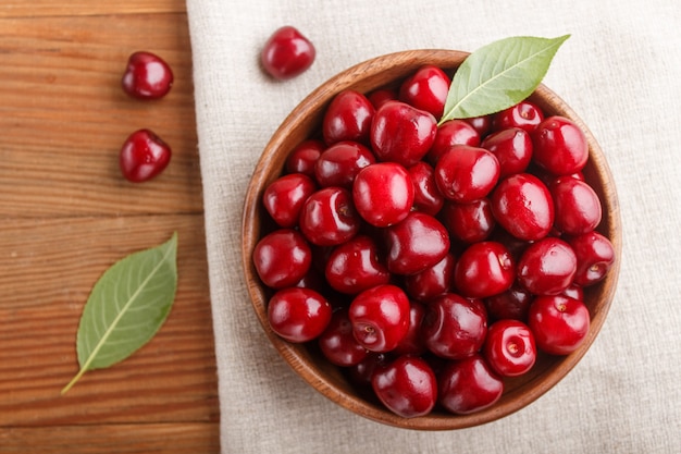 Fresh red sweet cherry in wooden bowl. top view.