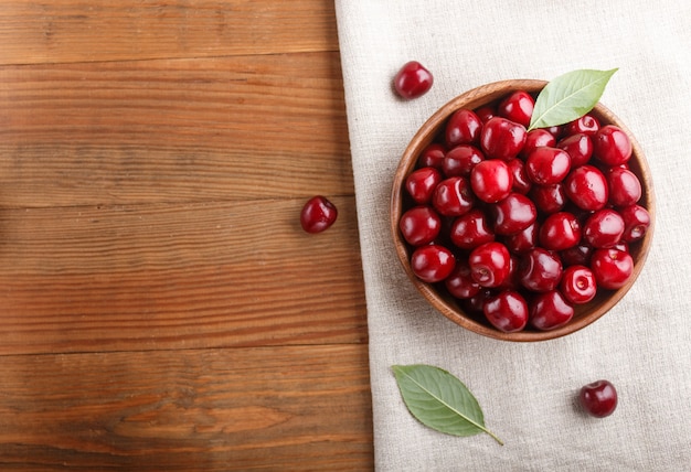 Fresh red sweet cherry in wooden bowl. top view.