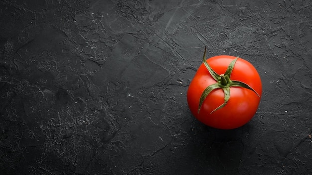 Fresh red tomatoes on a dark background Vegetables Top view Free space for your text