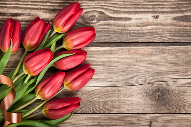 Fresh red tulips on wooden background