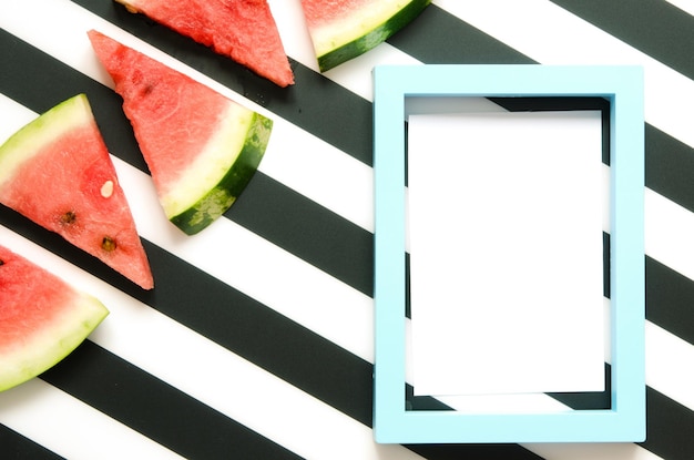 Photo fresh red watermelon slice on striped background with frame summer concept top view flat lay image