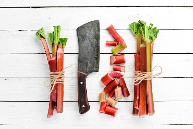 Fresh rhubarb on a white wooden background. Top view. Free copy space.