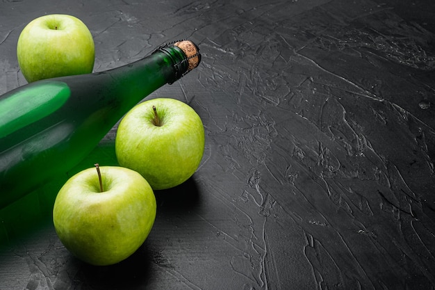 검은색 돌 탁자 배경에 있는 신선하게 익은 사과와 사과 사이다 식초 세트, 텍스트 복사 공간
