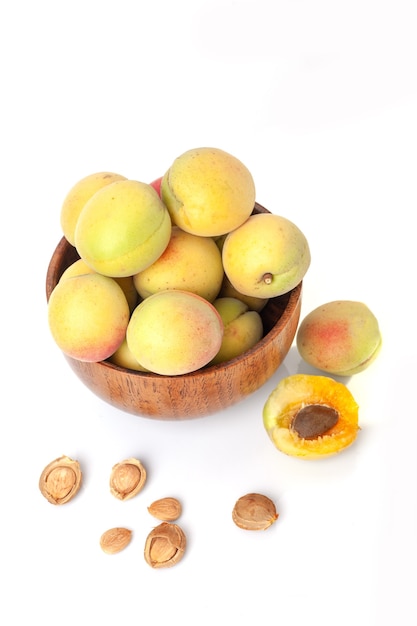 Fresh ripe apricots in wooden bowl isolated