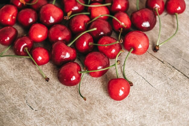 Fresh ripe cherries on wooden backgroundTop view Copy empty space for text