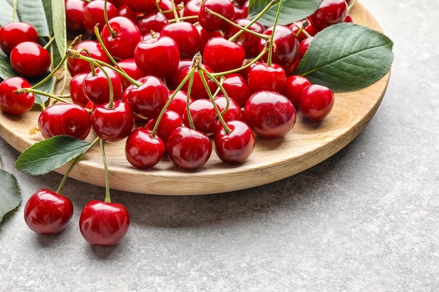 Fresh ripe cherries on wooden plate