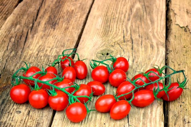 Foto pomodori ciliegia maturi freschi su vecchio fondo di legno.