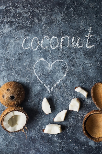 Photo fresh ripe coconut fruits in halfs over dark stone background