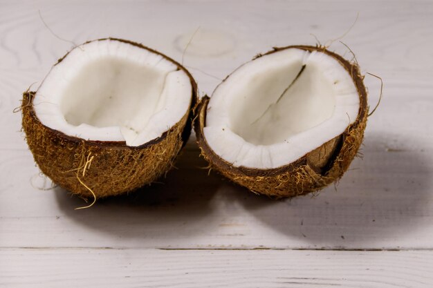 Fresh ripe coconut on white wooden table