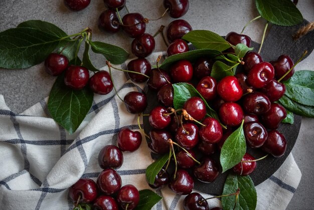 Fresh ripe dark cherries with green leaves