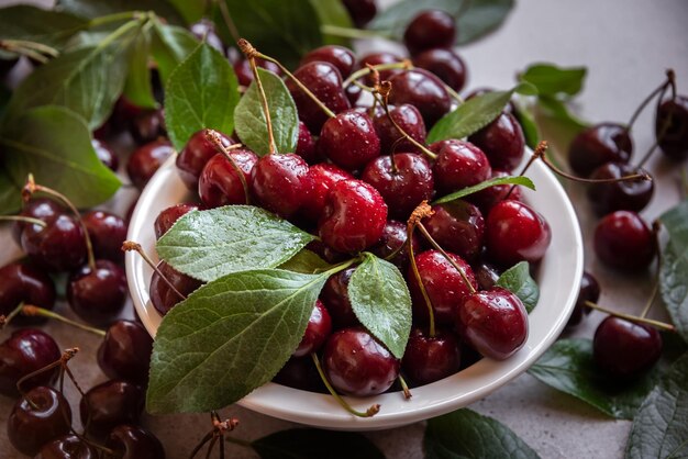 Fresh ripe dark cherries with green leaves