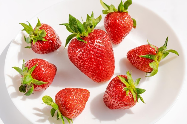 Fresh ripe delicious red strawberries in on a white plate on a white background