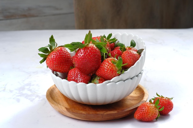 Fresh ripe delicious strawberries in white bowl isolated on white background