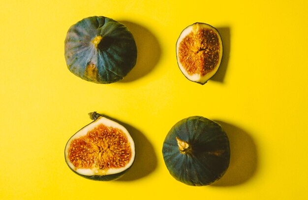 Fresh ripe figs on a yellow background Sweet sliced figs on the table View from above Copy space