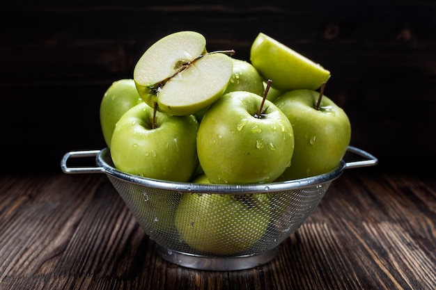 Fresh ripe green apples in a metal colander