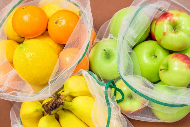 Fresh ripe and juicy fruits in reusable eco-friendly mesh bags.